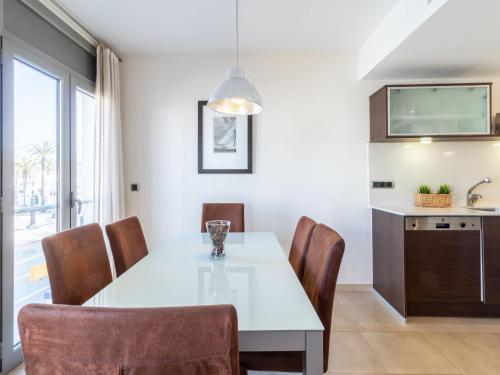 艾姆布里亚布拉瓦Apartment Del Port-4 by Interhome的厨房以及带白色桌椅的用餐室。