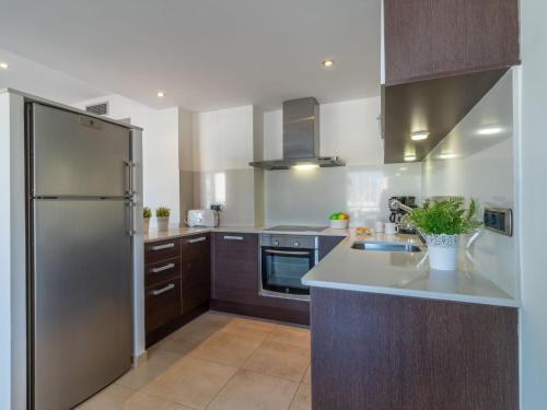 艾姆布里亚布拉瓦Apartment Del Port-5 by Interhome的厨房配有不锈钢冰箱和木制橱柜