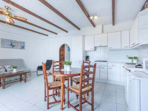 艾姆布里亚布拉瓦Apartment Las Chabolas by Interhome的厨房配有白色橱柜和木桌及椅子