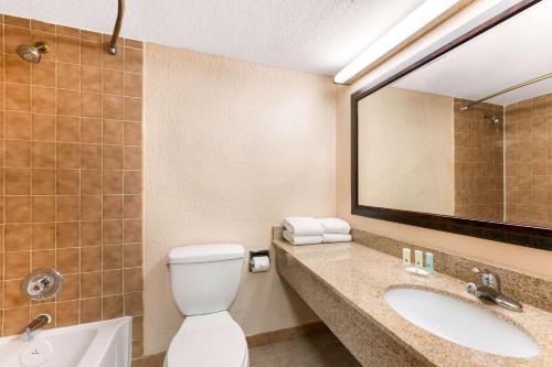 奥兰多Quality Inn & Suites Orlando Airport的一间带卫生间、水槽和镜子的浴室