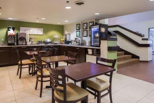 亚特兰大Sleep Inn Atlanta Airport的一间带桌椅的餐厅,以及楼梯
