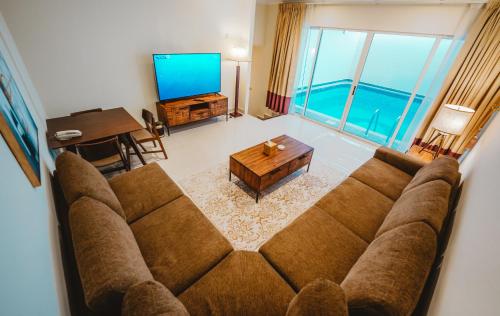 阿布扎比Villaggio Hotel Abu Dhabi的客厅配有沙发和桌子