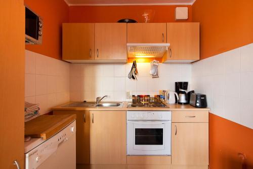 柏林阿莱克斯顶级景致&城市酒店的一个带橙色墙壁和水槽的小厨房