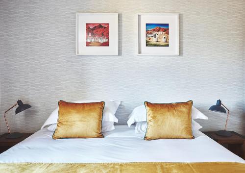 威廉堡Garrison Apartments的卧室配有两张墙上的照片和一张床
