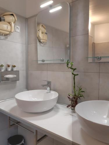 圣西尔-莱科勒圣西尔凡尔赛阿罗特尔酒店 - 寂静的舞台的一间带两个盥洗盆和大镜子的浴室