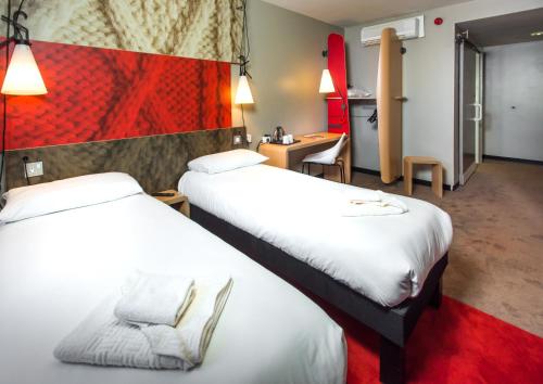 谢菲尔德Ibis Sheffield City的酒店客房配有两张床和一张书桌