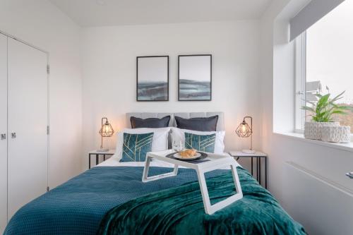 斯蒂夫尼奇Luxury Serviced Apartments Stevenage, Hertfordshire的一间卧室配有一张桌子和一张床铺