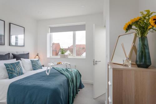斯蒂夫尼奇Luxury Serviced Apartments Stevenage, Hertfordshire的一间卧室,配有一张床和花瓶