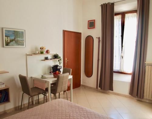 博洛尼亚B&B Casa Santina的一间带桌椅的房间和一间带床的房间