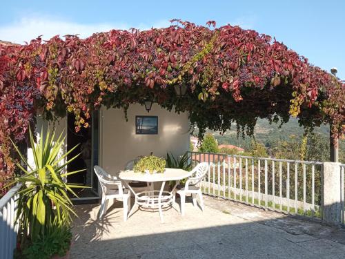 奥伦塞Casa MiraXurés con vistas a la Sierra del Xurés的阳台的天井配有桌椅