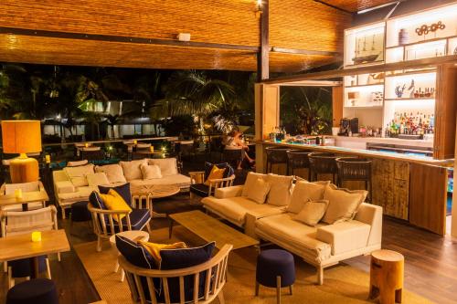 卡诺阿斯德蓬萨尔蓬塔萨尔套房和别墅度假酒店的一间带沙发和桌子的餐厅和一间酒吧