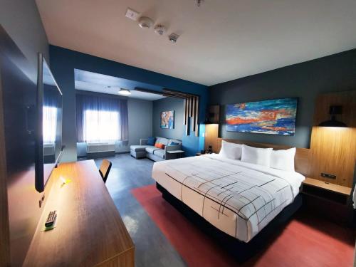 斯托克顿堡La Quinta Inn & Suites by Wyndham Fort Stockton Northeast的一间带大床的卧室和一间客厅