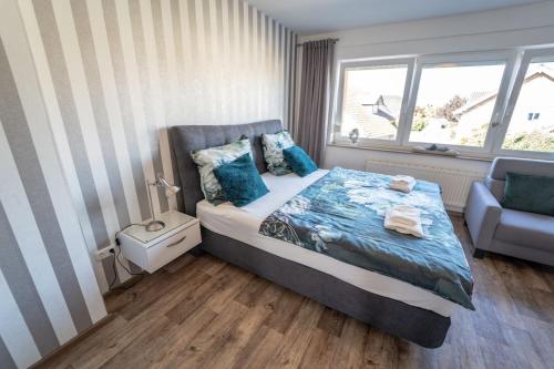海因斯贝格Ferienwohnung Anke - Appartement 5c的卧室配有床、椅子和窗户。