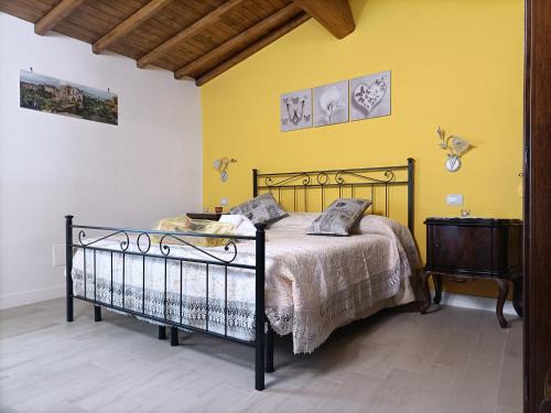 博马尔佐B&B Il Grifo的一间卧室设有一张床和黄色的墙壁