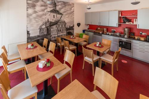 班贝格Hotel am Brauerei-Dreieck的一间带桌椅的餐厅和一间厨房
