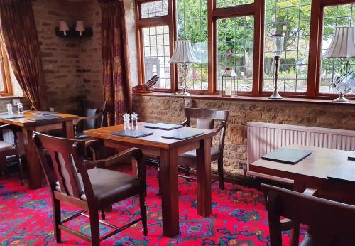 斯托昂泽沃尔德Stow Lodge Hotel的用餐室设有桌椅和窗户。