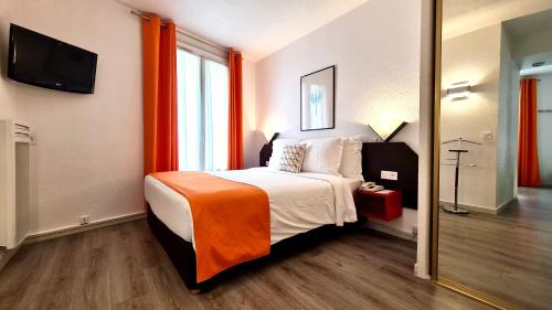 布洛涅-比扬古布洛涅家庭酒店的一间卧室配有一张带橙色毯子的床