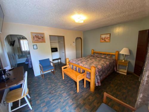 瑟莫波利斯Rainbow Motel的卧室配有一张床和一张桌子及椅子
