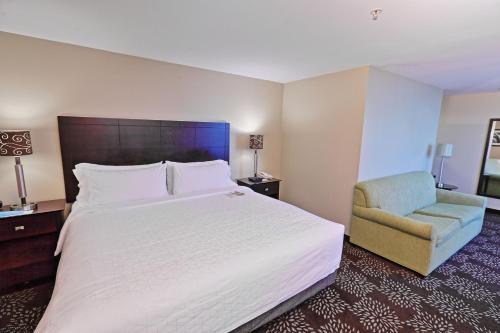 匹兹堡匹兹堡西部-格林豪泰智选假日酒店的酒店客房带一张大床和一把椅子