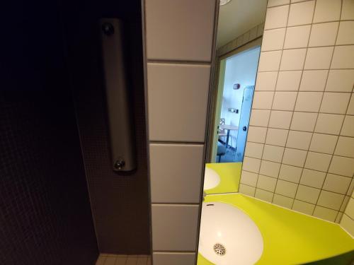 斯特拉斯堡Auberge de Jeunesse HI Strasbourg 2 Rives的浴室设有黄色水槽和镜子