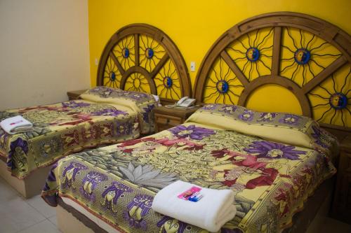 科利马Hotel Morelos Colima的带彩色玻璃窗的客房内的两张床