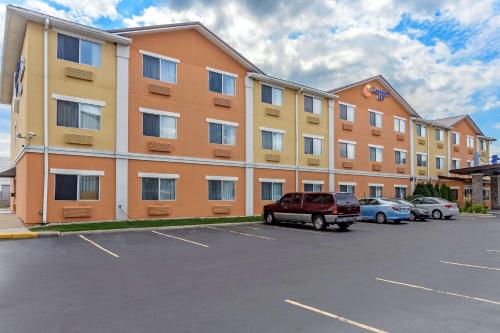 格尼Comfort Inn Gurnee near Six Flags的停车场内停放汽车的大型建筑