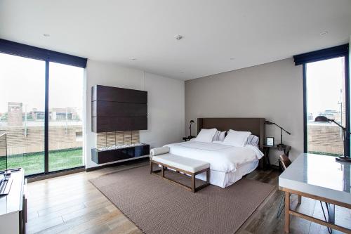 波哥大Attik Luxury Apts的卧室设有白色的床和大窗户