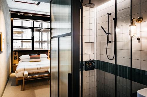 堪培拉欧沃洛尼施酒店的带淋浴的浴室和一张床。