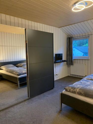 阿尔特瑙Ferienwohnung am Rothenberg的一间卧室设有两张床和滑动玻璃门
