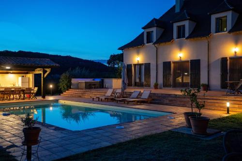 CalèsMaison de Vacances - Domaine de la Couvée的一座晚上设有游泳池的房子