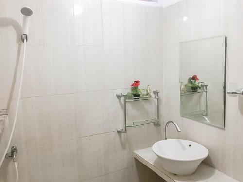 井里汶Rumah Panggung Guest House Syariah Mitra RedDoorz的白色的浴室设有水槽和镜子