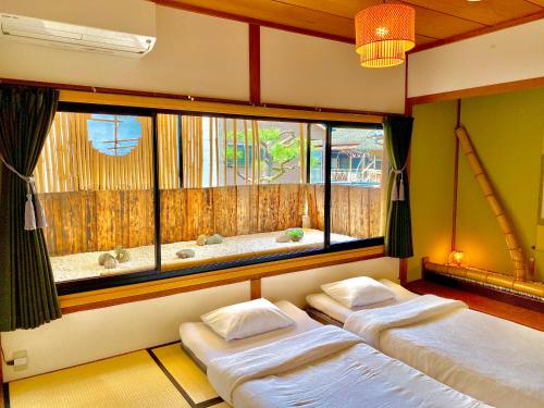 京都近江旅馆的配有2张床的带窗户和浴缸的客房