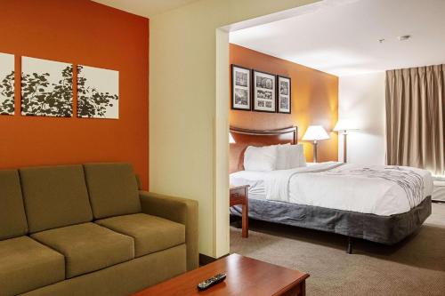 霍布斯Sleep Inn & Suites的酒店客房,配有床和沙发