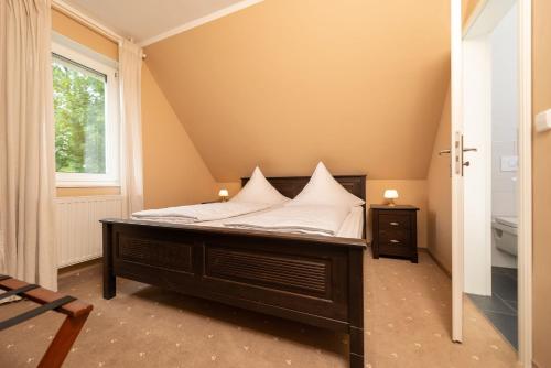 萨勒河畔瑙姆堡Hotel Wasserschlößchen的一间卧室配有带白色枕头的床
