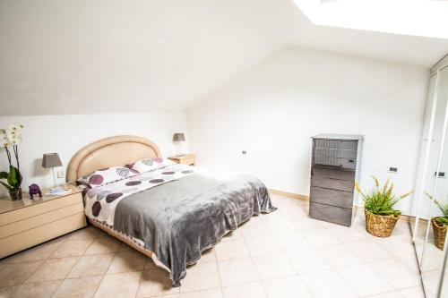 圣雷莫Mansarda luminosa in centro a Sanremo的卧室设有一张大床,铺有瓷砖地板。