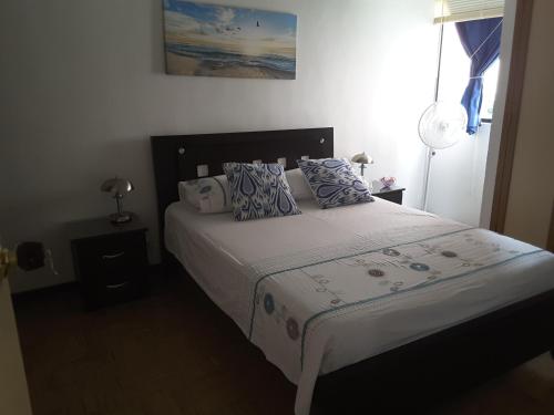 卡利Apartment Riberas的一间卧室配有一张带蓝色和白色枕头的床