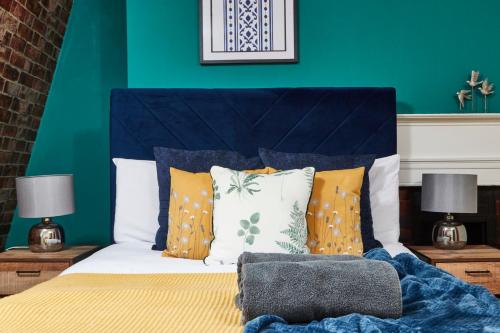 巴斯The Stunning Duplex Gem in The Heart of Bath的一间卧室配有一张蓝色墙壁的床