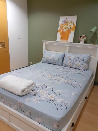曼谷班素青年旅舍的一张带鲜花的蓝色棉被的床