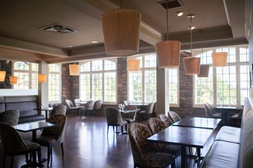 Windermere温德米尔豪斯酒店的用餐室设有桌椅和窗户。