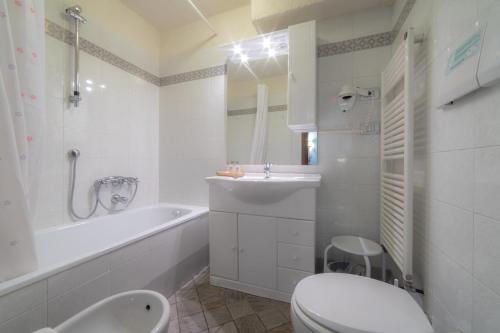 布勒伊-切尔维尼亚Hotel Astoria的白色的浴室设有浴缸、卫生间和水槽。
