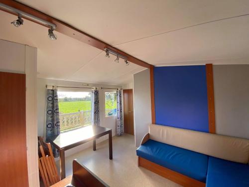 索克斯Camping La Baie du Mont Saint Michel的带沙发和蓝色墙壁的客厅
