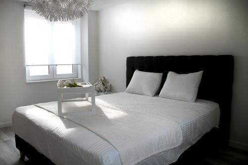 斯普里蒙Appartement Blanc cocooning的一间卧室配有一张床,上面有床头柜