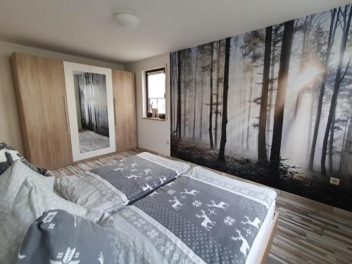 贝伦斯泰因Ferienwohnung "Waldzauber"的一间卧室配有床和带海报的墙壁