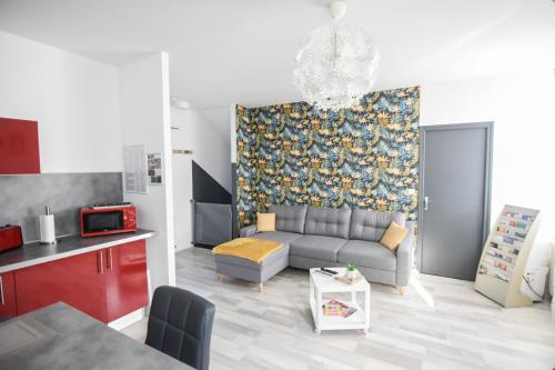 圣康坦Appartement "le Terminus " Gare-Cosy-Wifi 6 Personnes的一间带灰色沙发的客厅和一间厨房