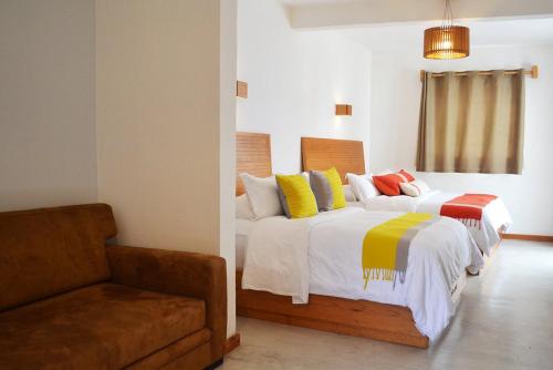 圣克里斯托瓦尔-德拉斯卡萨斯Casa Cafeólogo的一间卧室配有两张带彩色枕头和沙发的床。