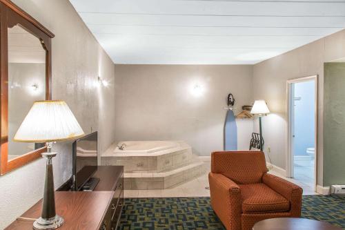 克兰斯顿Econo Lodge Cranston - Providence的客厅配有椅子和浴缸