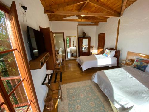 萨兰托Terrazas de Salento的一间卧室配有两张床和一台电视。
