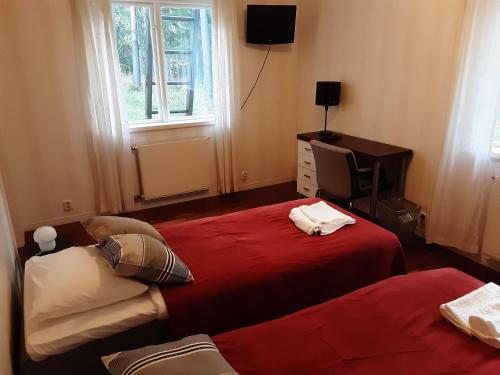 EuraVilla Majatalot的一间卧室设有两张床、一台电视和一扇窗户。
