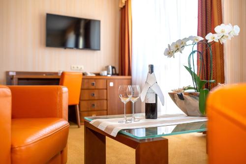 梅尔诺Dworek Morski SPA & Wellness的客厅配有一张桌子和两杯葡萄酒