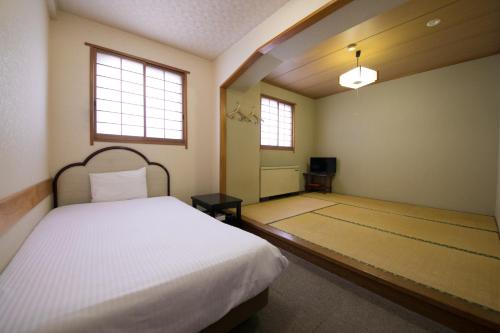 福冈黒瓦代奥特蒙酒店的一间卧室配有一张床和一台电视。
